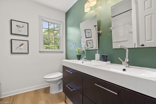 317 Benbow Dr, East Bend, NC 27018 - full bathroom with double vanity, toilet, wood finished floors, and baseboards