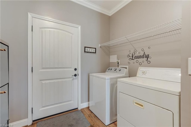 washroom with washer and dryer, crown molding, and light hardwood / wood-style floors