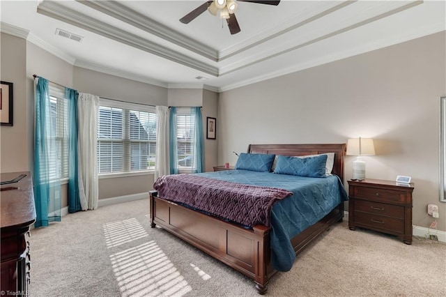 carpeted bedroom with ceiling fan, a raised ceiling, and crown molding