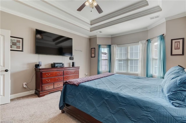 carpeted bedroom featuring a raised ceiling, ceiling fan, and ornamental molding