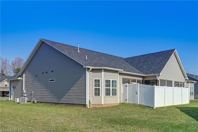 rear view of house featuring a yard and central AC unit