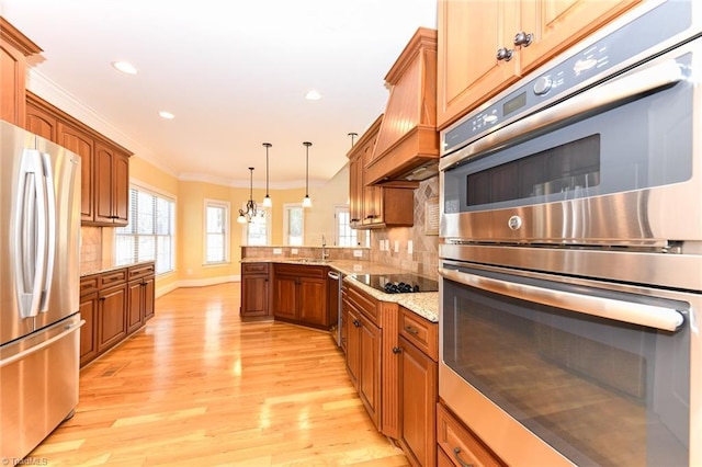 kitchen featuring light stone countertops, appliances with stainless steel finishes, decorative light fixtures, decorative backsplash, and crown molding