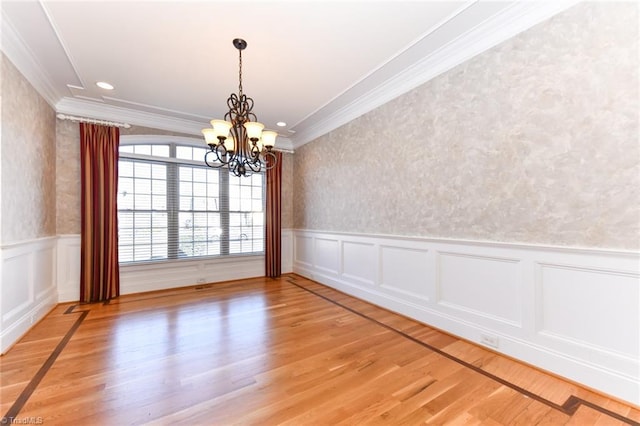 unfurnished dining area featuring a chandelier, ornamental molding, and wood-type flooring