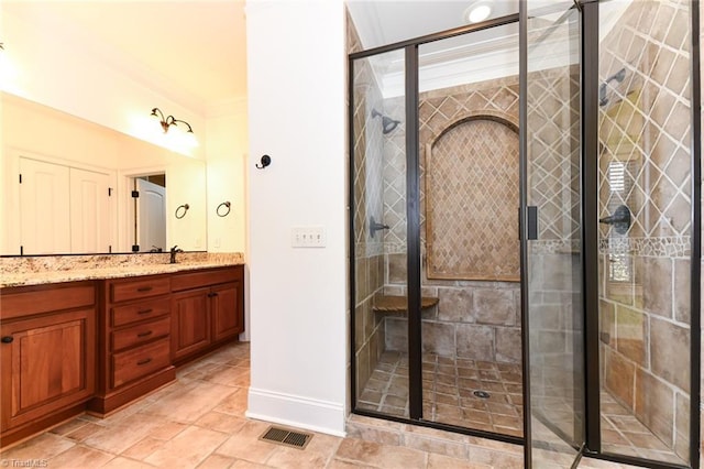 bathroom with a shower with shower door, vanity, and crown molding