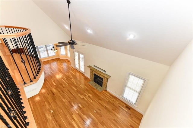 unfurnished living room with light hardwood / wood-style floors, high vaulted ceiling, and ceiling fan