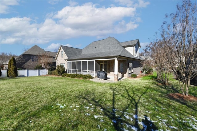 back of property featuring a patio area, a sunroom, and a yard