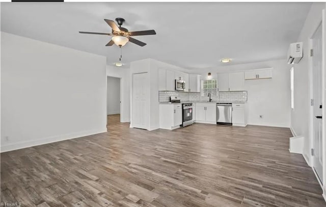 unfurnished living room with ceiling fan, a sink, dark wood-style floors, and baseboards