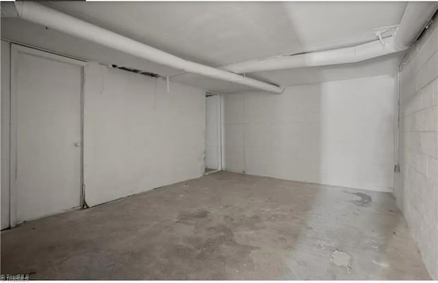 unfinished basement featuring concrete block wall