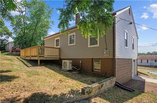 back of property with ac unit, a wooden deck, a lawn, and a chimney