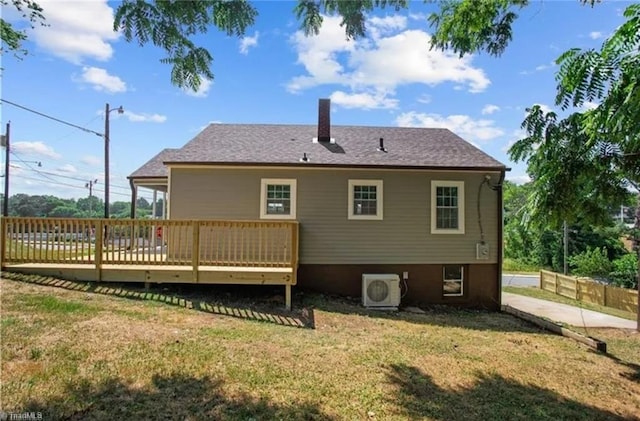 rear view of property featuring ac unit, a wooden deck, a yard, fence, and a chimney