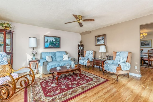 living room with ceiling fan, light hardwood / wood-style floors, and a textured ceiling