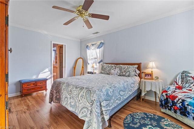 bedroom featuring connected bathroom, ceiling fan, crown molding, and wood-type flooring