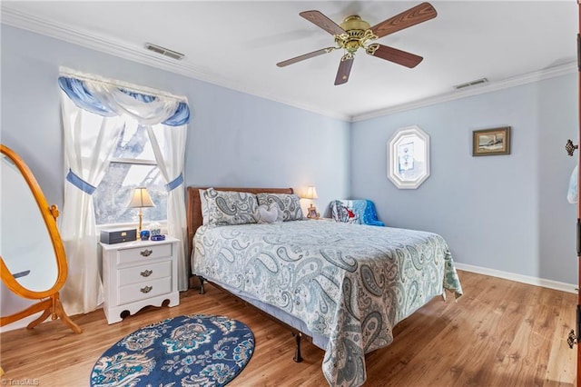 bedroom with light hardwood / wood-style floors, ceiling fan, and crown molding