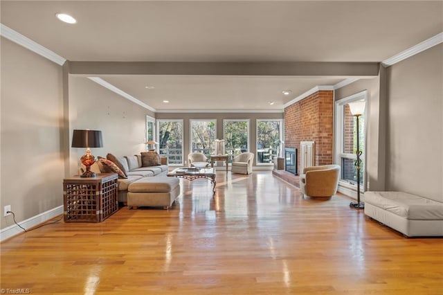 living room with light hardwood / wood-style floors, a brick fireplace, and ornamental molding