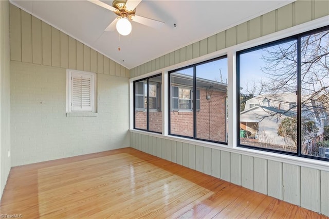 unfurnished sunroom featuring ceiling fan and vaulted ceiling