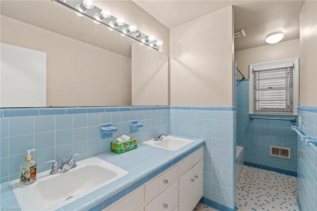 bathroom featuring shower / tub combination, vanity, and tile walls