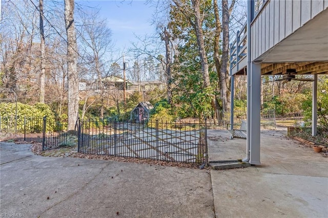 view of gate with ceiling fan and a patio