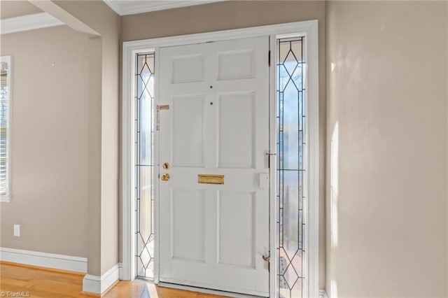 foyer entrance with light hardwood / wood-style flooring and crown molding