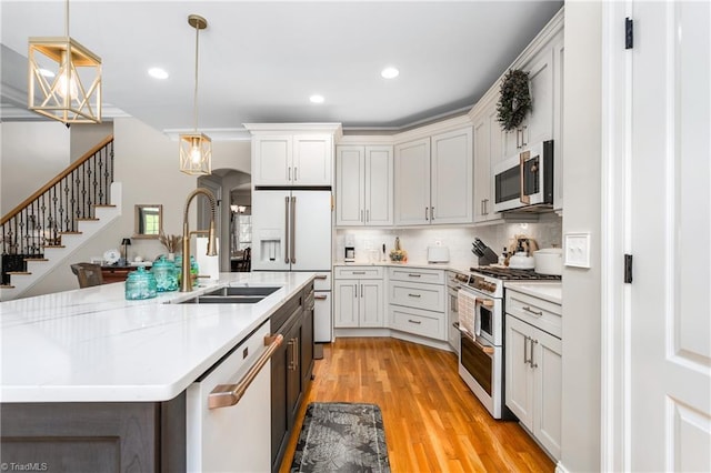 3303 Tanner Ct, Summerfield, NC 27358 - kitchen featuring decorative light fixtures, light wood finished floors, a sink, high end appliances, and backsplash