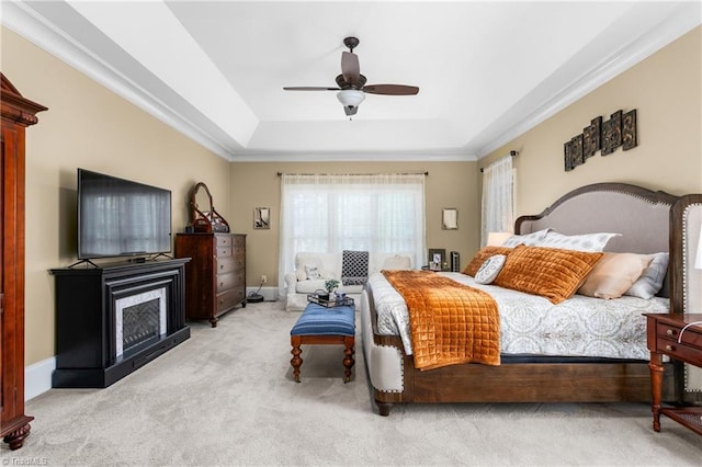 3303 Tanner Ct, Summerfield, NC 27358 - carpeted bedroom featuring a ceiling fan, a tray ceiling, a fireplace, baseboards, and ornamental molding