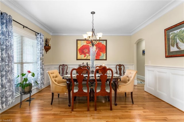 3303 Tanner Ct, Summerfield, NC 27358 - dining room featuring arched walkways, ornamental molding, light wood finished floors, and a chandelier