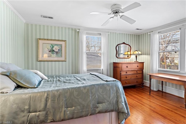 bedroom with visible vents, wallpapered walls, and crown molding