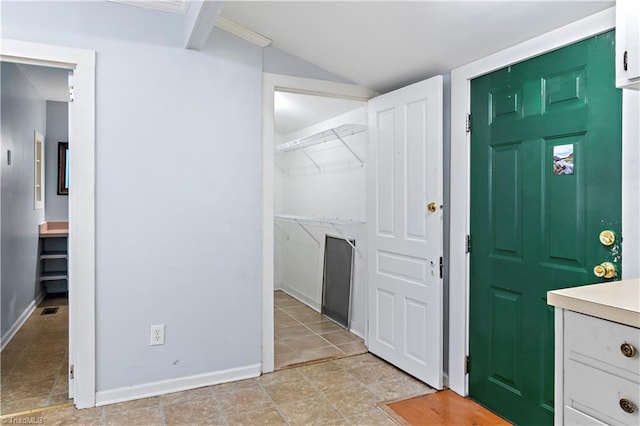 entryway with baseboards and lofted ceiling