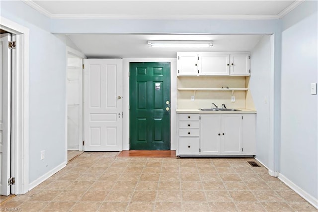 kitchen featuring white cabinets, baseboards, visible vents, and a sink