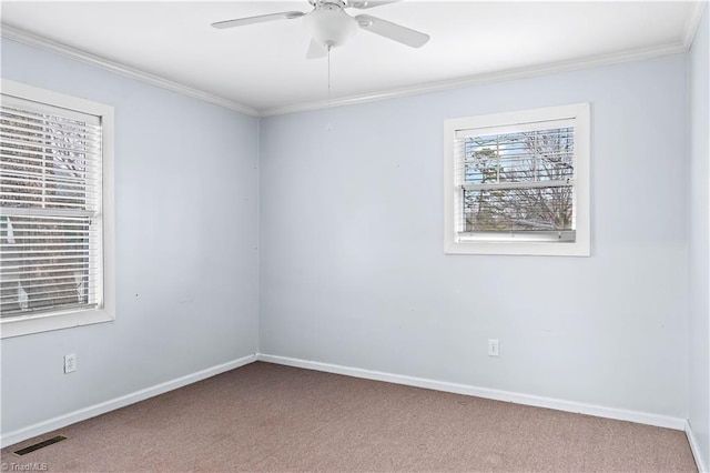 empty room with visible vents, carpet floors, baseboards, and ornamental molding