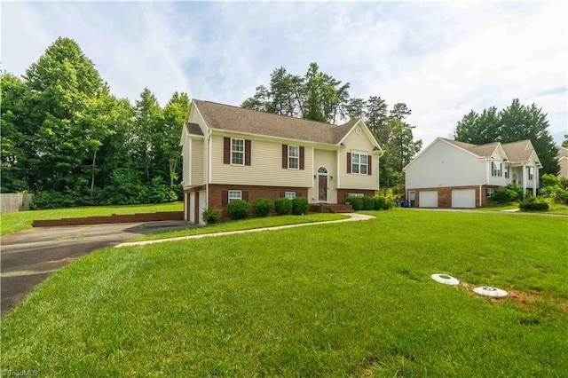 6919 Channel Forest Rd, Belews Creek, NC 27009 - raised ranch featuring asphalt driveway, a garage, a front yard, and brick siding