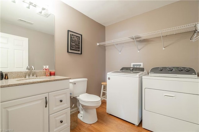 6919 Channel Forest Rd, Belews Creek, NC 27009 - bathroom with washing machine and dryer, wood finished floors, and vanity