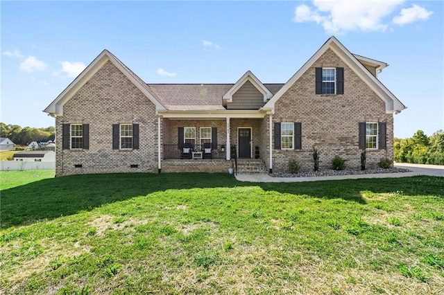 view of front facade featuring brick siding, crawl space, covered porch, and a front yard