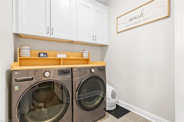 clothes washing area featuring washing machine and dryer, baseboards, tile patterned flooring, and cabinet space