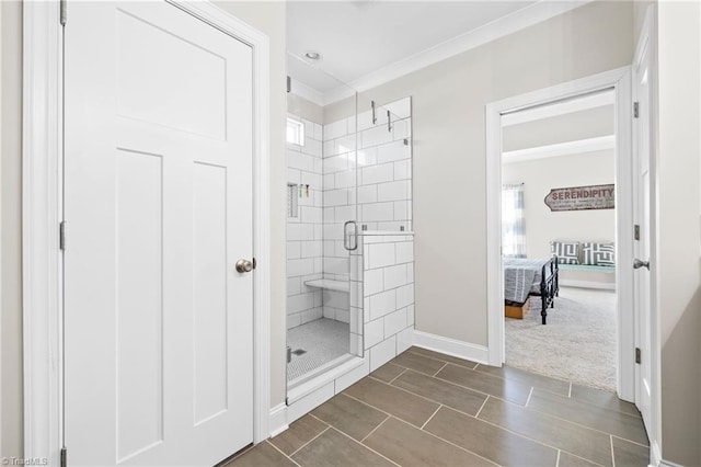 full bath featuring a shower stall, crown molding, and baseboards