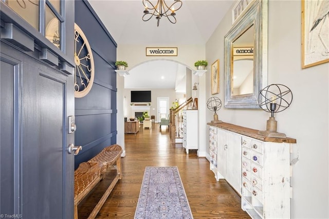 hallway featuring dark wood finished floors and arched walkways