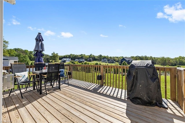 wooden deck featuring outdoor dining area and a grill