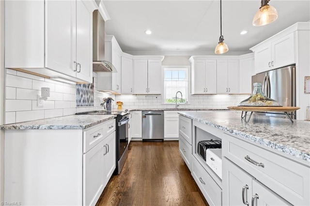 kitchen with wall chimney range hood, appliances with stainless steel finishes, and white cabinetry
