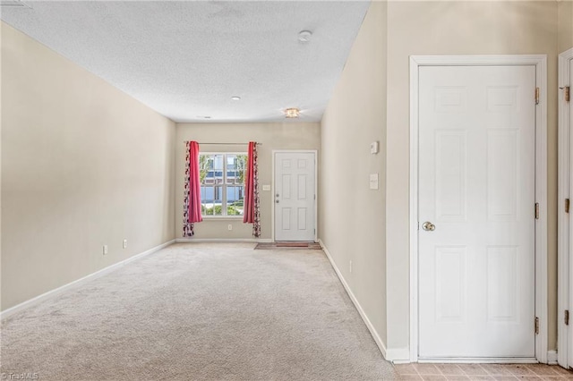 carpeted spare room featuring a textured ceiling