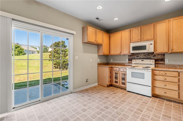 kitchen with light brown cabinetry, light stone counters, white appliances, and backsplash