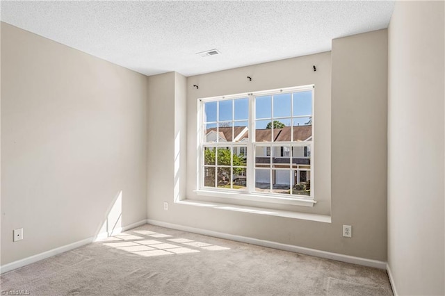 carpeted spare room with a textured ceiling