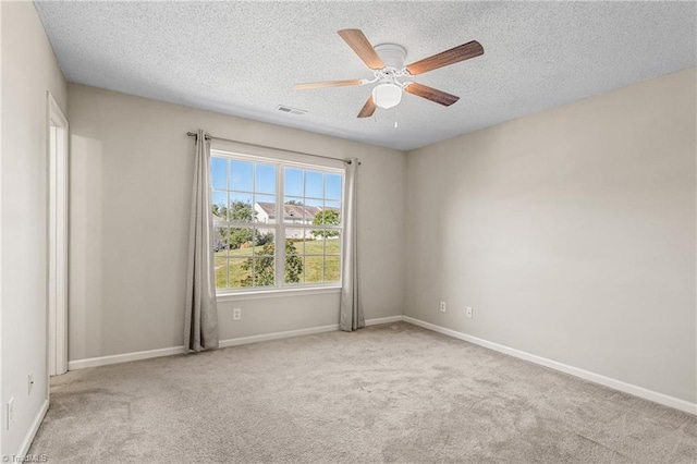 spare room featuring ceiling fan, a textured ceiling, and light carpet