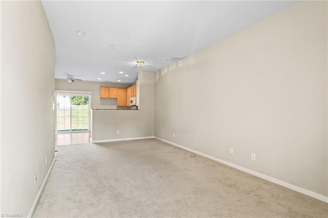 unfurnished living room with light carpet and ceiling fan