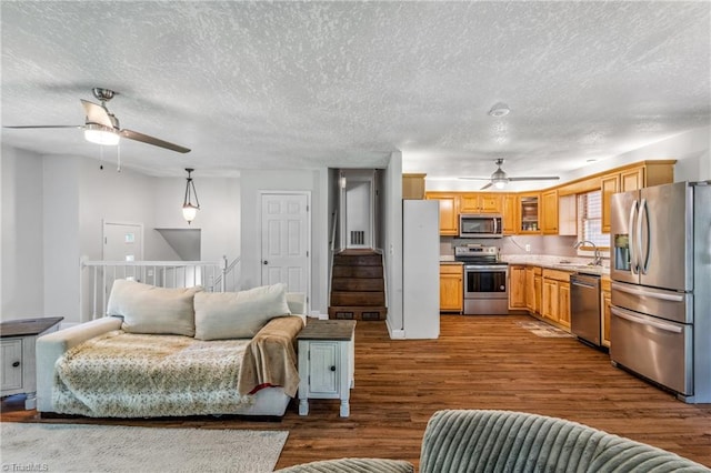 living room with sink, ceiling fan, hardwood / wood-style floors, and a textured ceiling