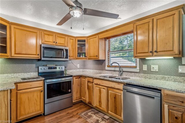 kitchen featuring ceiling fan, dark wood-type flooring, sink, a textured ceiling, and stainless steel appliances