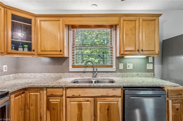 kitchen with sink, dishwasher, tasteful backsplash, and light stone countertops