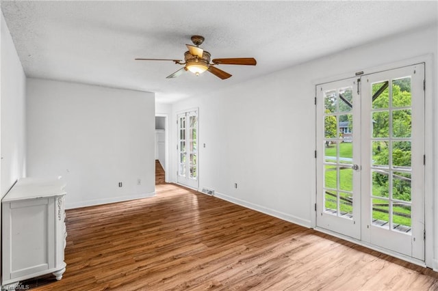 unfurnished room with ceiling fan, french doors, and wood-type flooring