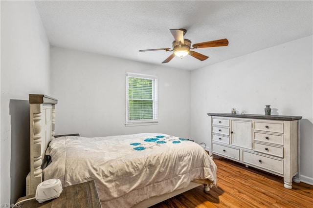 bedroom featuring a textured ceiling, ceiling fan, and wood-type flooring