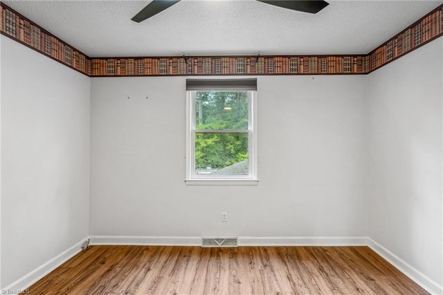 unfurnished room with ceiling fan, hardwood / wood-style flooring, and a textured ceiling