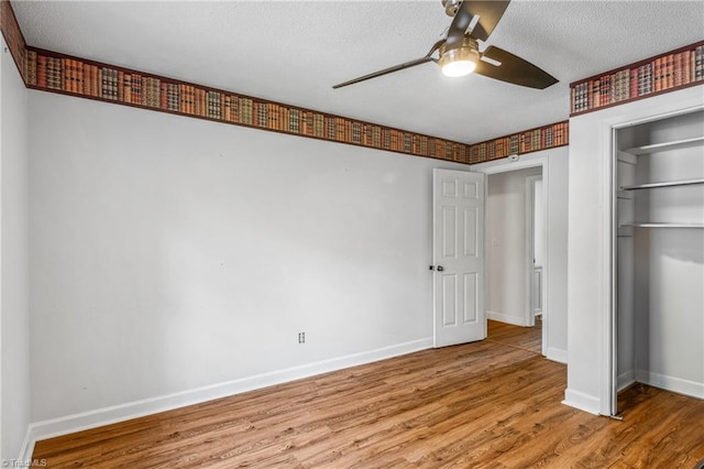 unfurnished bedroom featuring hardwood / wood-style flooring, a closet, a textured ceiling, and ceiling fan