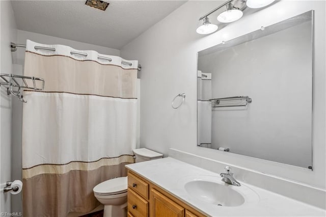 bathroom with a textured ceiling, toilet, and vanity